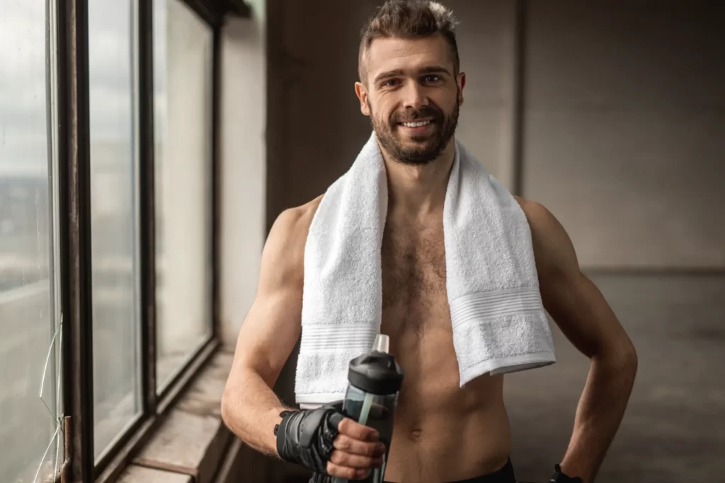 happy man with towel and bottle of water after wor utc